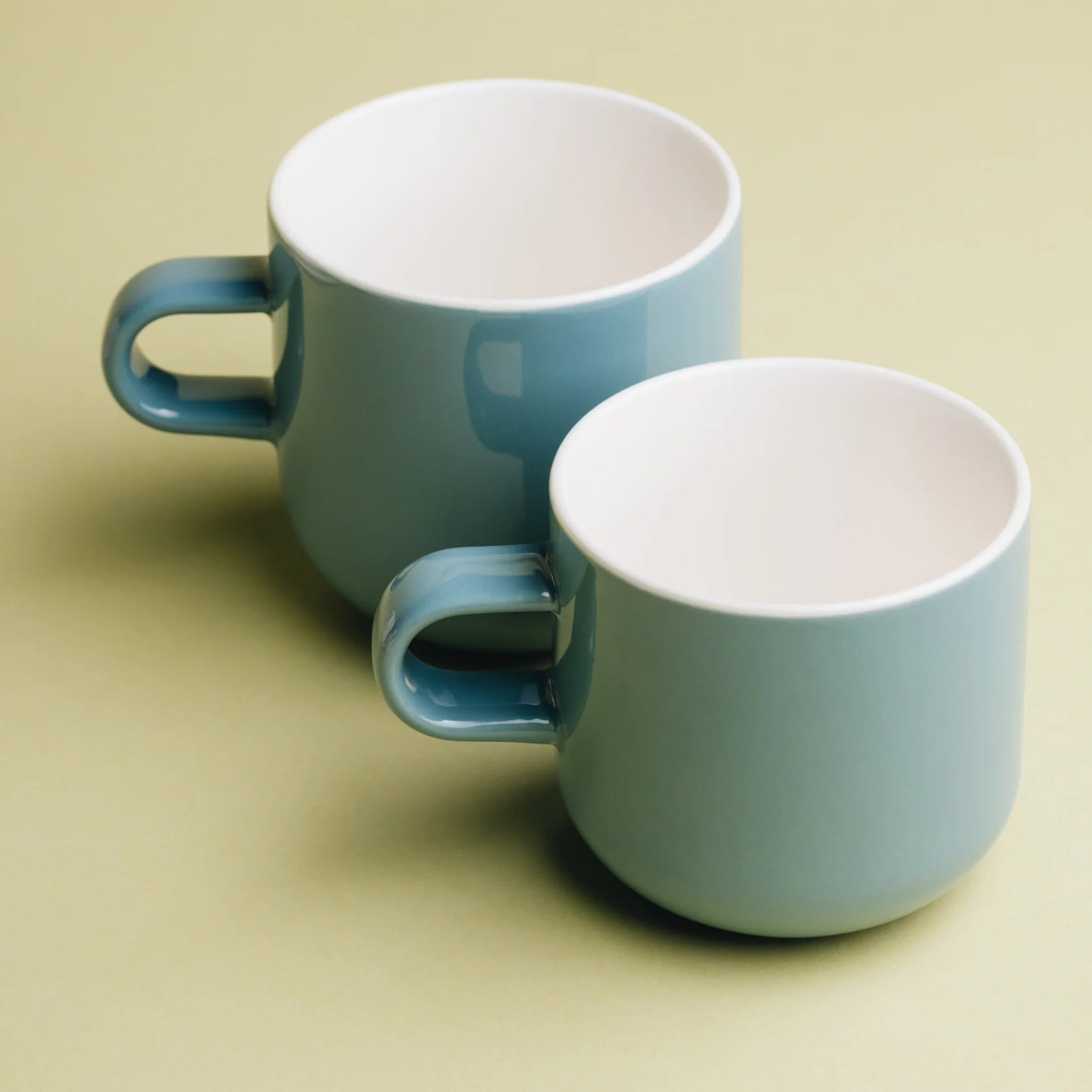 Acme Bobby Mug Kōkako 300ml and 400ml sizes side by side — blue-grey porcelain mugs, white interior, Aunty Tommy&